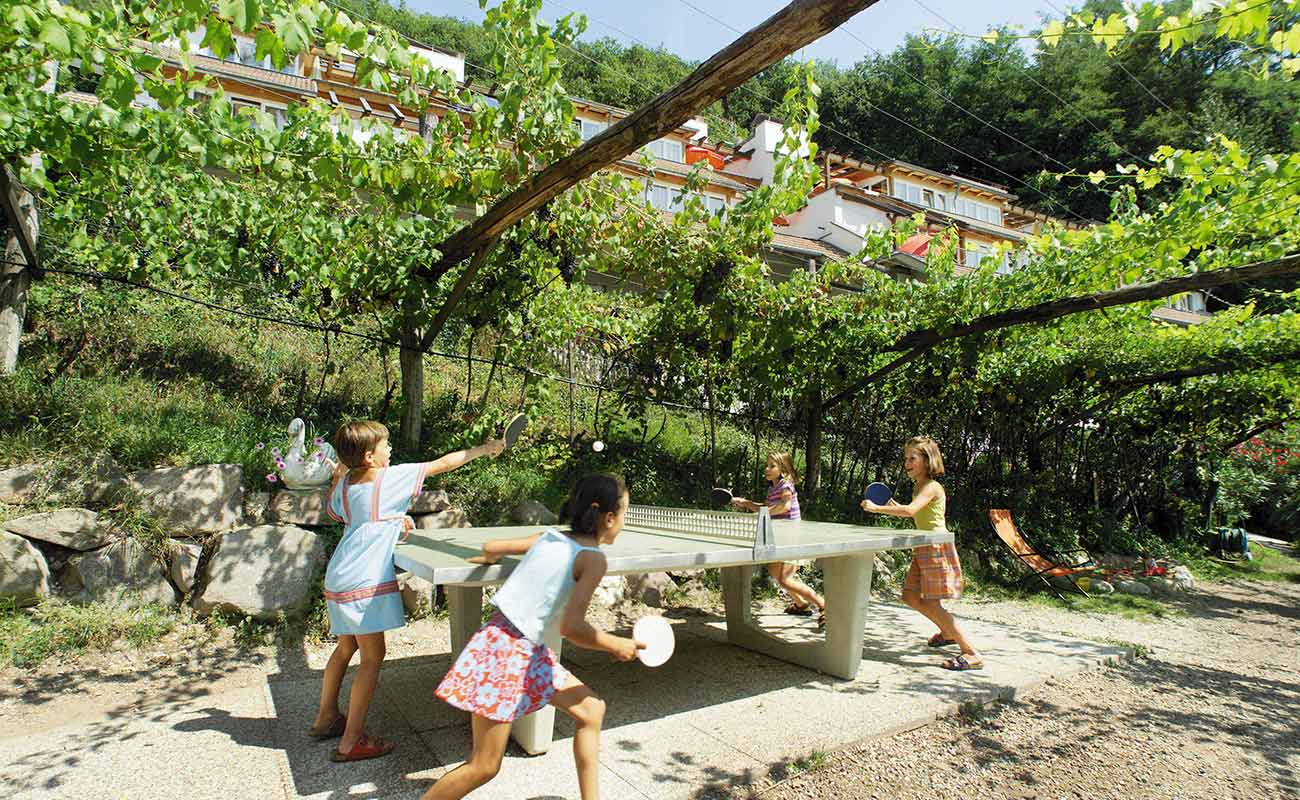 Kinder beim Ping-Pong Spielen im Garten des Residence Kalterer See
