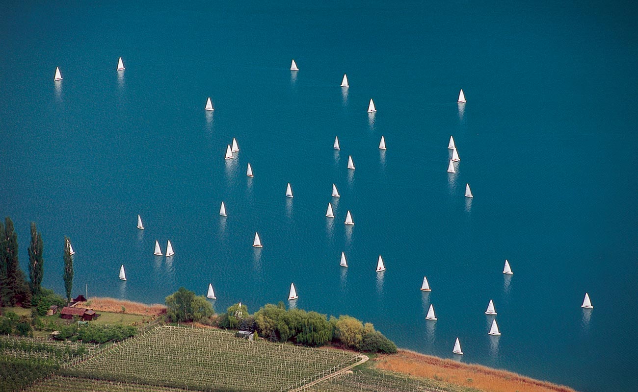 Viele Segelboote auf dem Kalterer See, von hoch oben in der Ferne gesehen