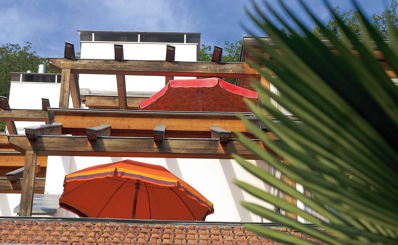 Nahaufnahme der Pergolas auf den Terrassen vom Residence Haus Kalteresee in Kaltern mit roten Sonnenschrimen