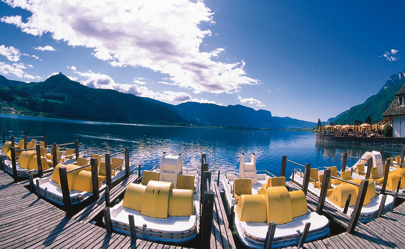 Pedal boats moored on the shore of Lake Caldaro