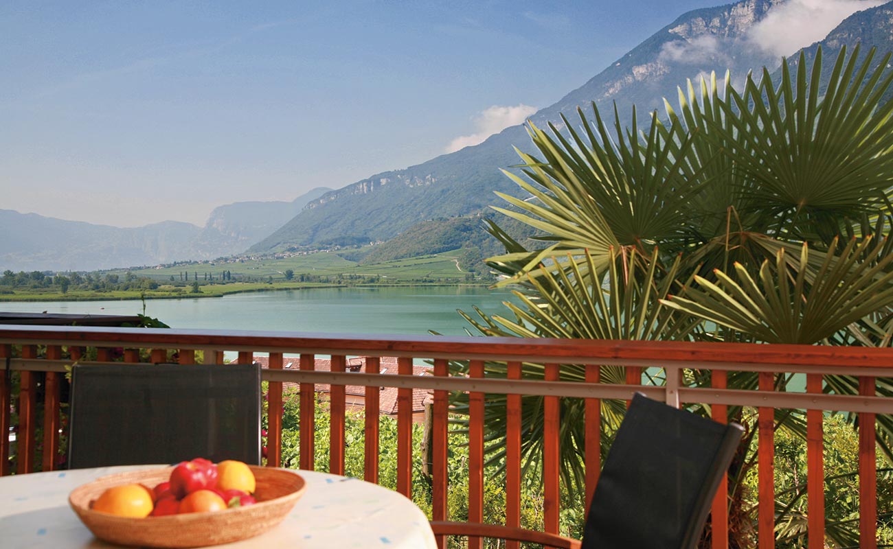 Tisch und zwei Stühle auf der Terrasse einer ferienwohnung im Residence Haus Kalterer See